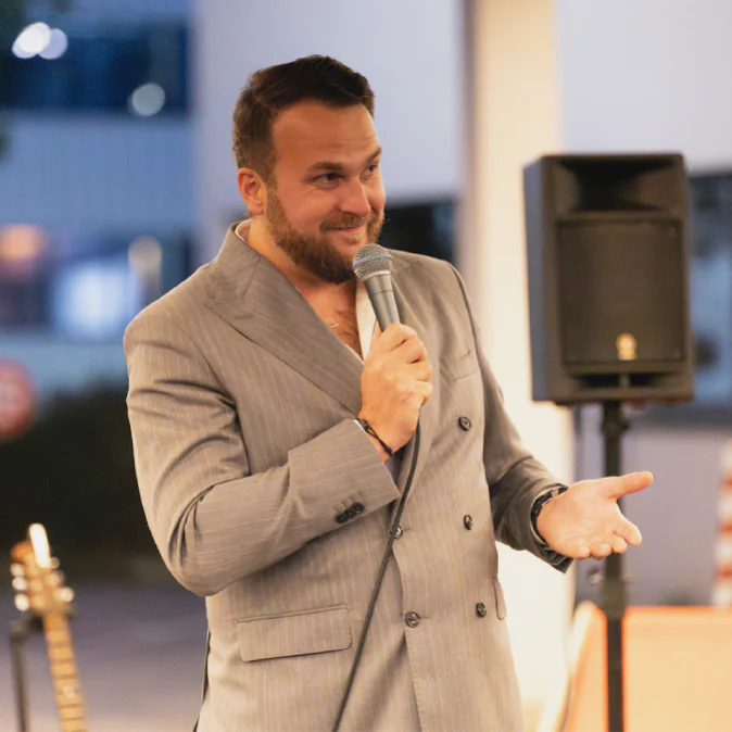 Photo de Maximilien, sur une scène, en train de présenter Clementine lors d'un événement